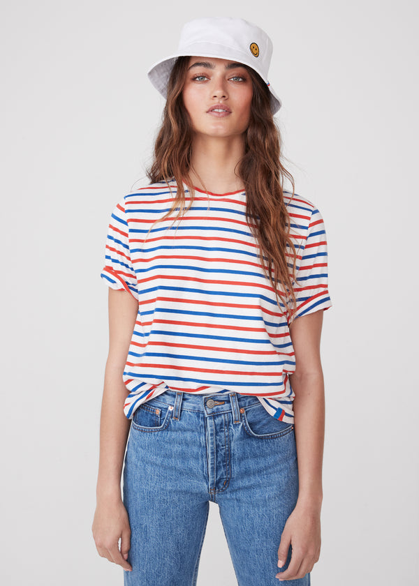 Model wearing The Modern in white/true blue/poppy tee with jeans and white bucket hat